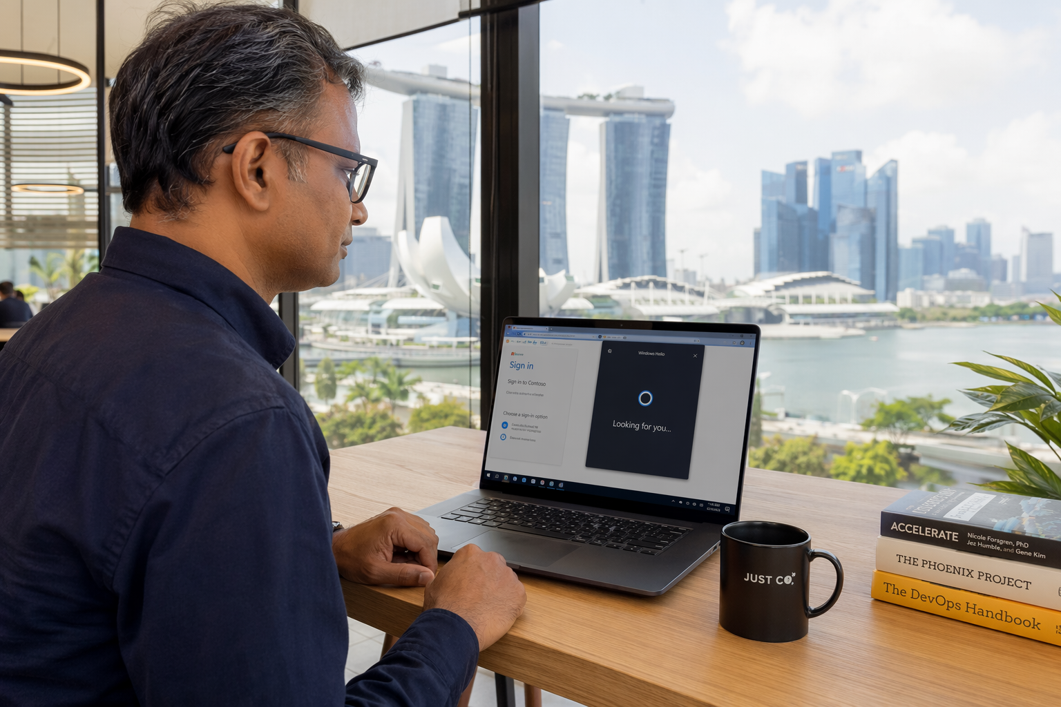 رجل ينظر إلى كاميرا حاسوبه المحمول بينما يصادق Windows Hello على هويته في صفحة دخول بلا كلمة مرور وأفق مارينا باي خلفه